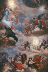 A classical painting depicting a celestial scene with numerous figures, including angels, saints, and reclining nude figures, surrounded by clouds. The composition is divided into sections, with people engaging in gestures and interactions, suggesting spiritual or religious significance.