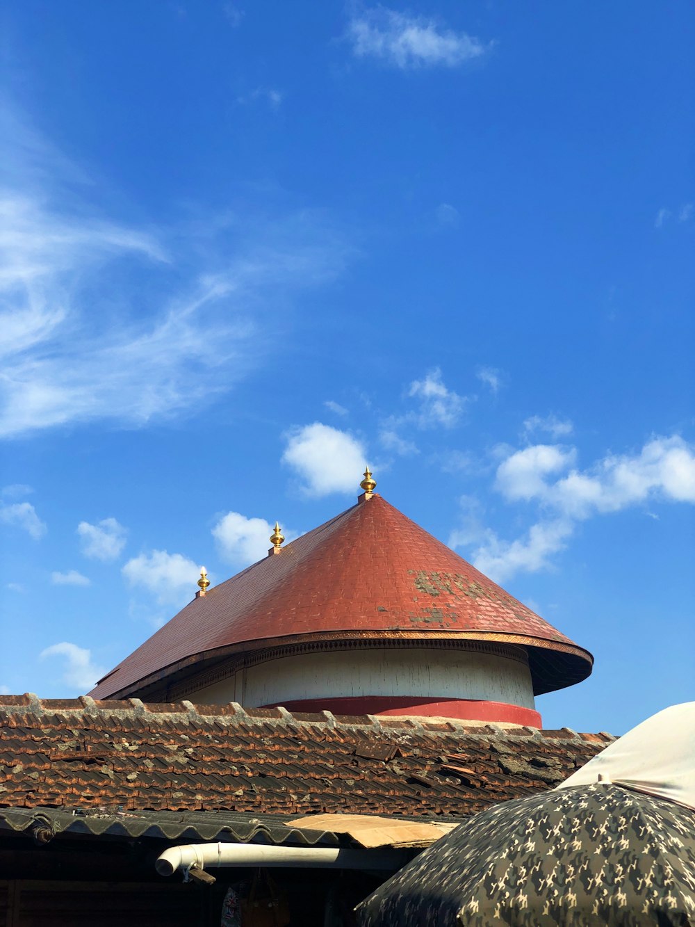 Edificio de hormigón marrón y blanco bajo el cielo azul durante el día