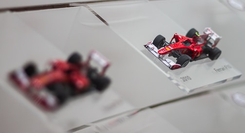 A detailed model of an F1 car on a workbench with tools around.