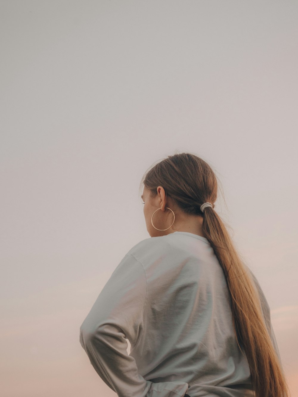 woman in white shirt looking at the sky