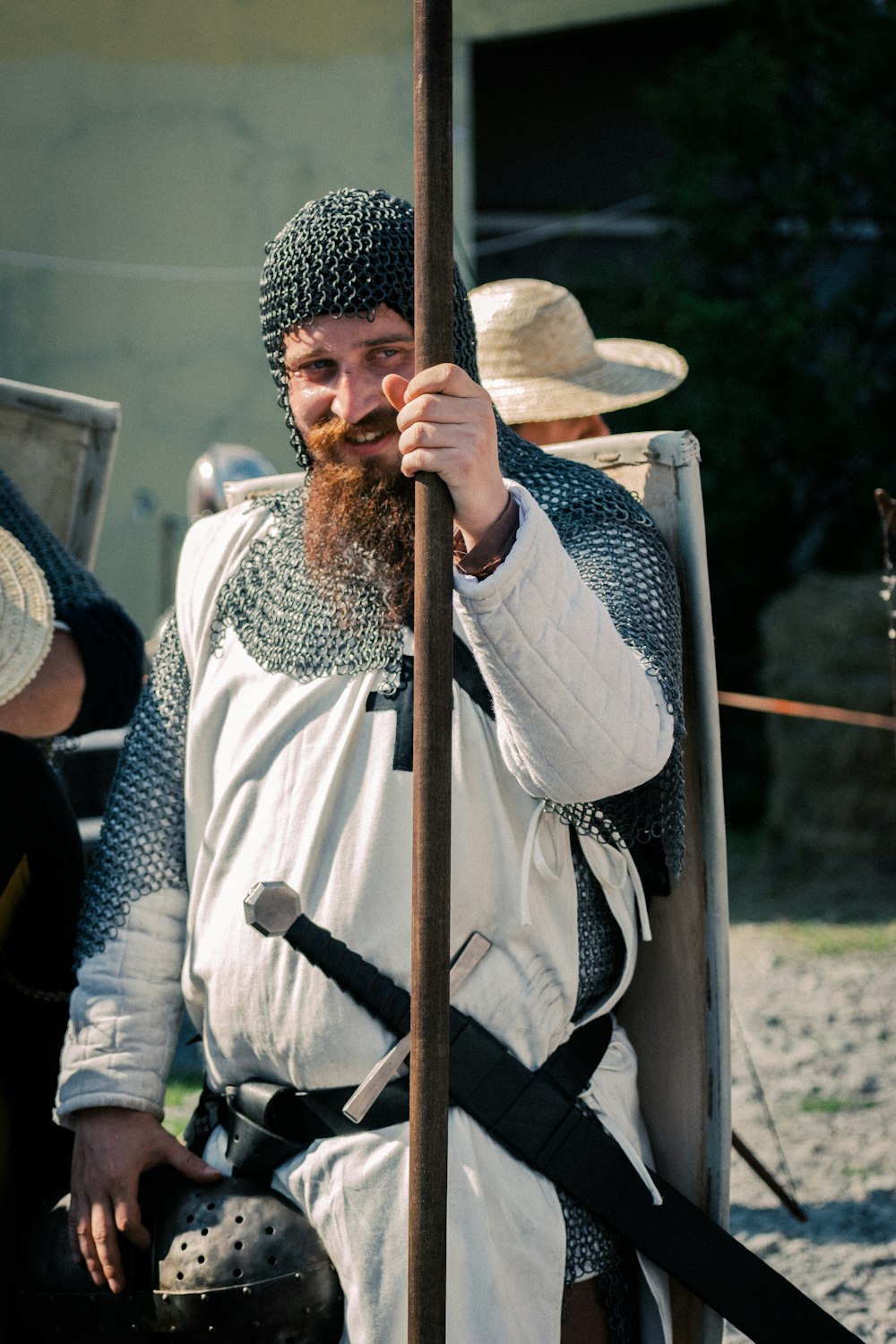 man in white and black long sleeve shirt holding brown wooden stick