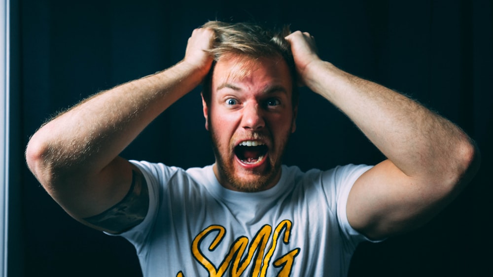 homem na camiseta branca e azul do pescoço da tripulação