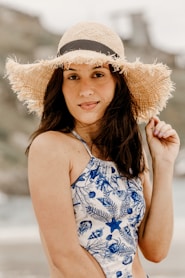 woman in blue and white floral tank top wearing brown sun hat