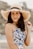 woman in blue and white floral tank top wearing brown sun hat