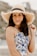 woman in blue and white floral tank top wearing brown sun hat