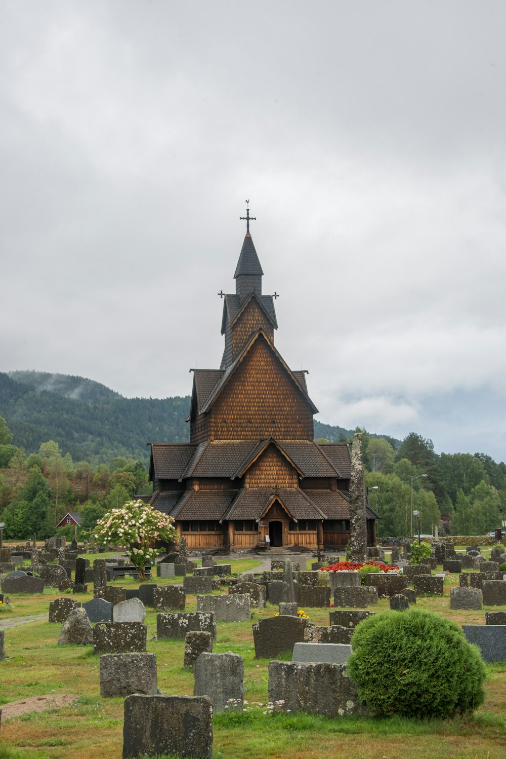 brown and black concrete church near green trees under white sky during daytime