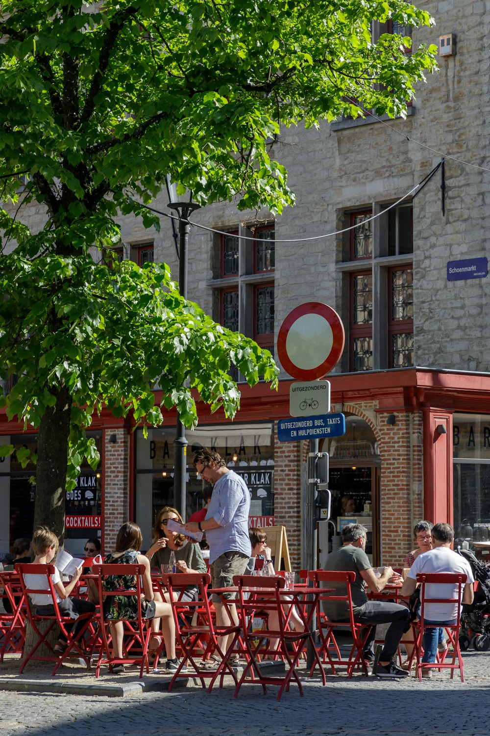 people sitting on red chairs near brown concrete building during daytime