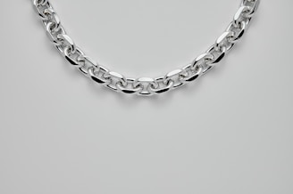 A sleek gold chain catching the light, showcasing its smooth and polished finish.