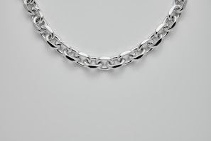 silver chain link bracelet on white surface
