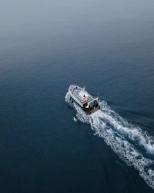 Sport fishing boat cutting through calm blue waters at sunrise.