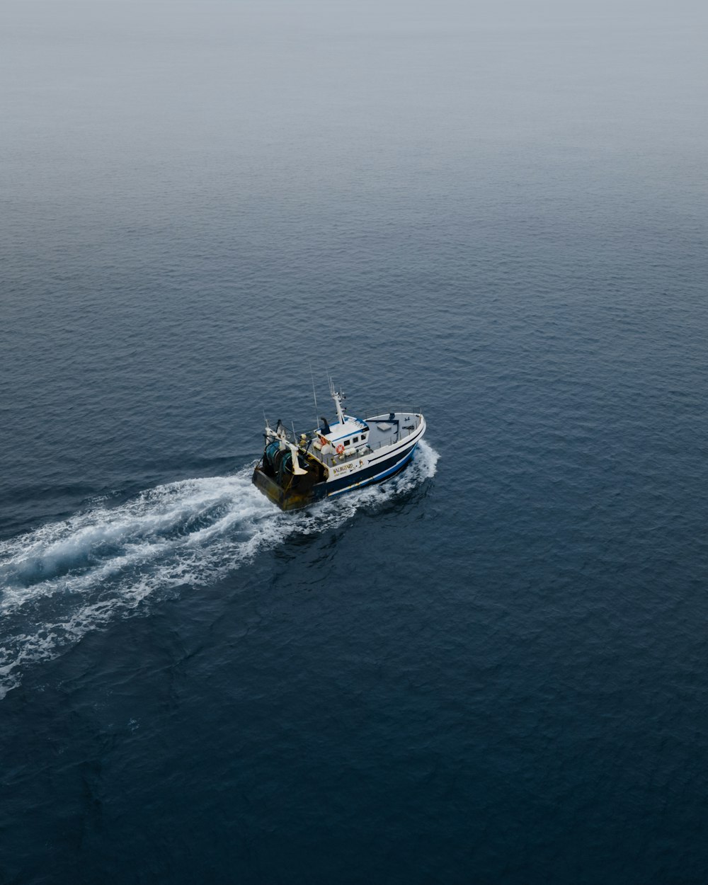 weißes und schwarzes Boot tagsüber auf See