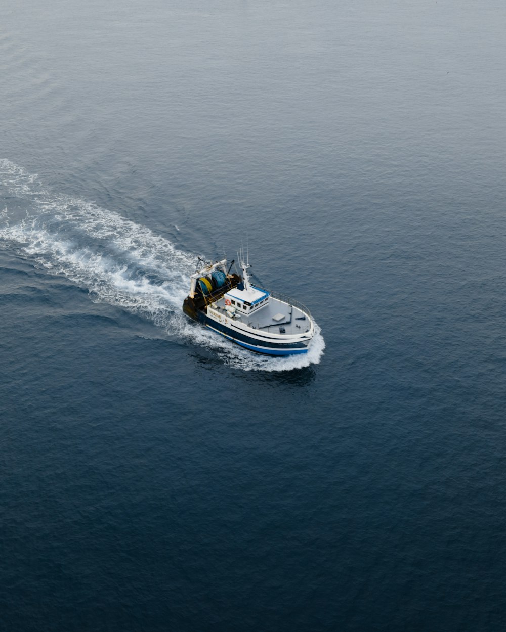 white and blue boat on sea during daytime