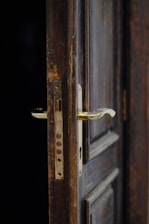 Close-up of a hand opening a heavy, old door symbolizing hidden fears.