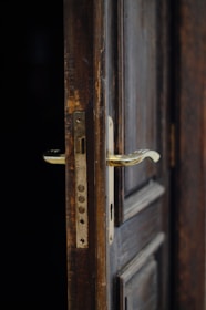 Close-up of a hand opening a heavy, old door symbolizing hidden fears.