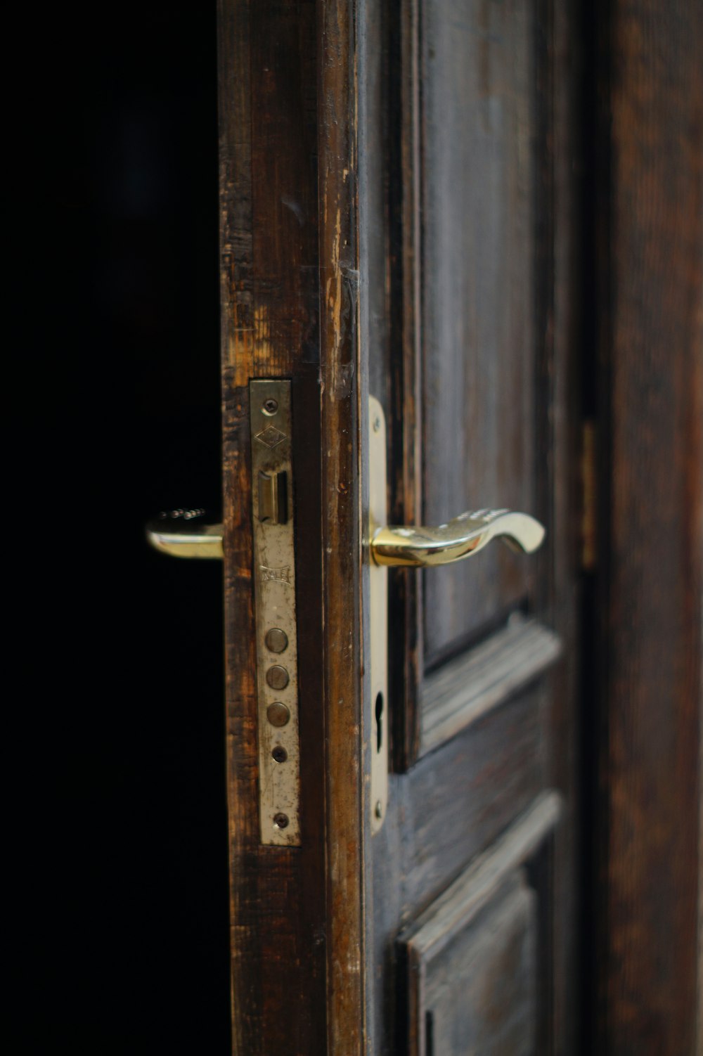 Leva della porta dorata su porta in legno marrone