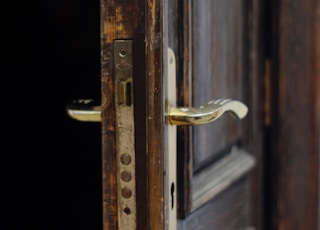 gold door lever on brown wooden door