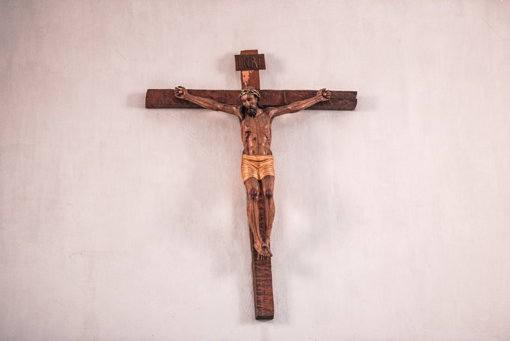 cruz de madera marrón sobre pared blanca