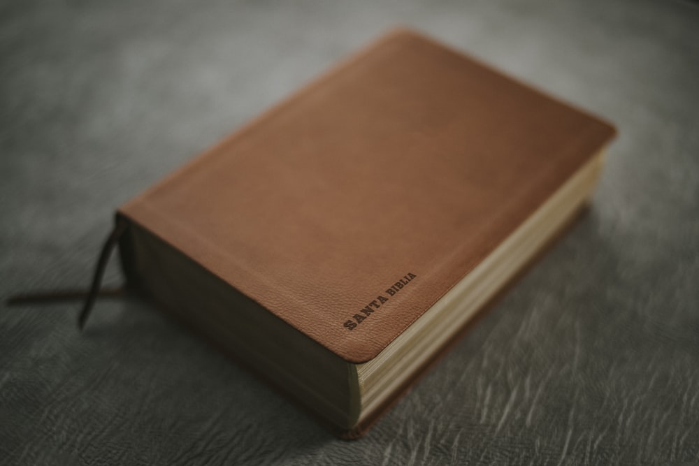 Livre marron sur table en bois noir