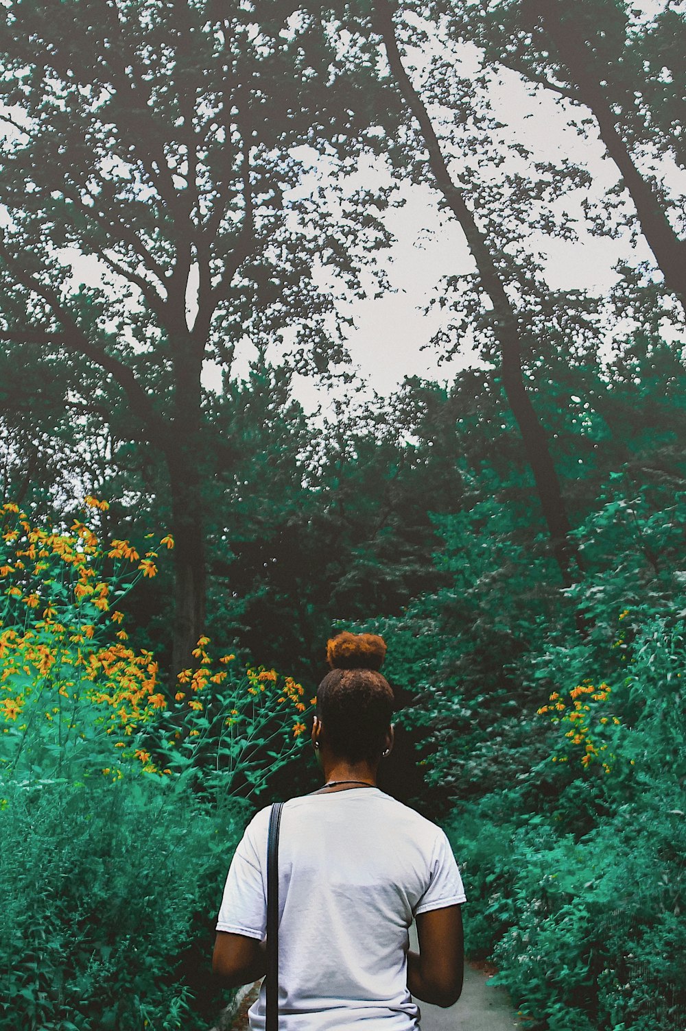 man in white shirt standing near green trees during daytime