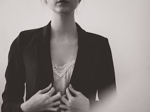 A soft, neutral-toned photo of a model wearing a sleek, modern blazer paired with tailored trousers, embodying effortless elegance.