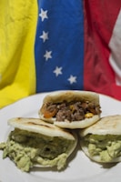 Colorful Venezuelan arepas stacked on a rustic wooden table.