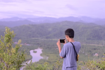A traveler using a smartphone in a scenic location.