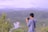 A traveler enjoying a scenic view while using their phone.