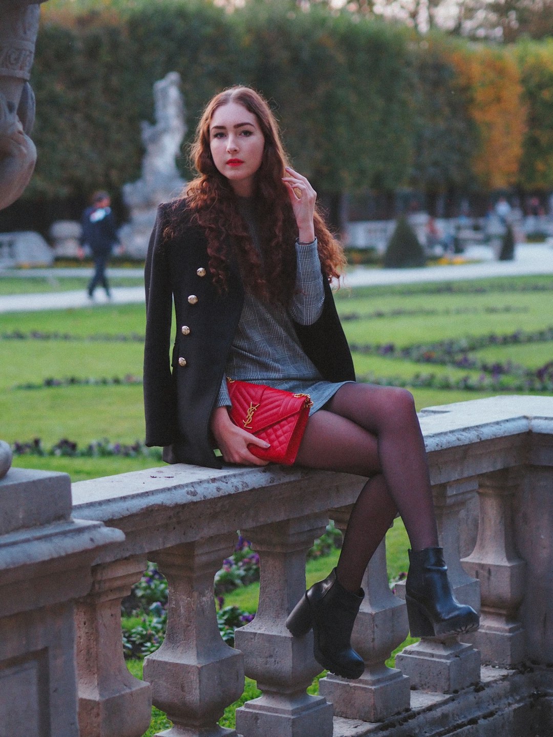 woman in black long sleeve shirt sitting on brown wooden bench during daytime