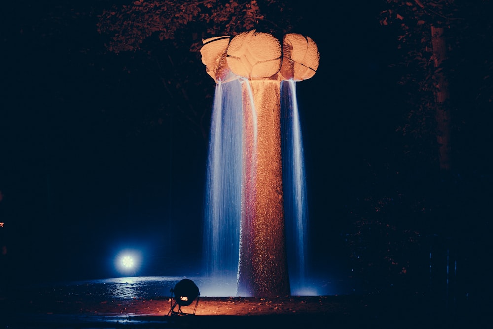 man in black shirt standing near white lighted tower during night time