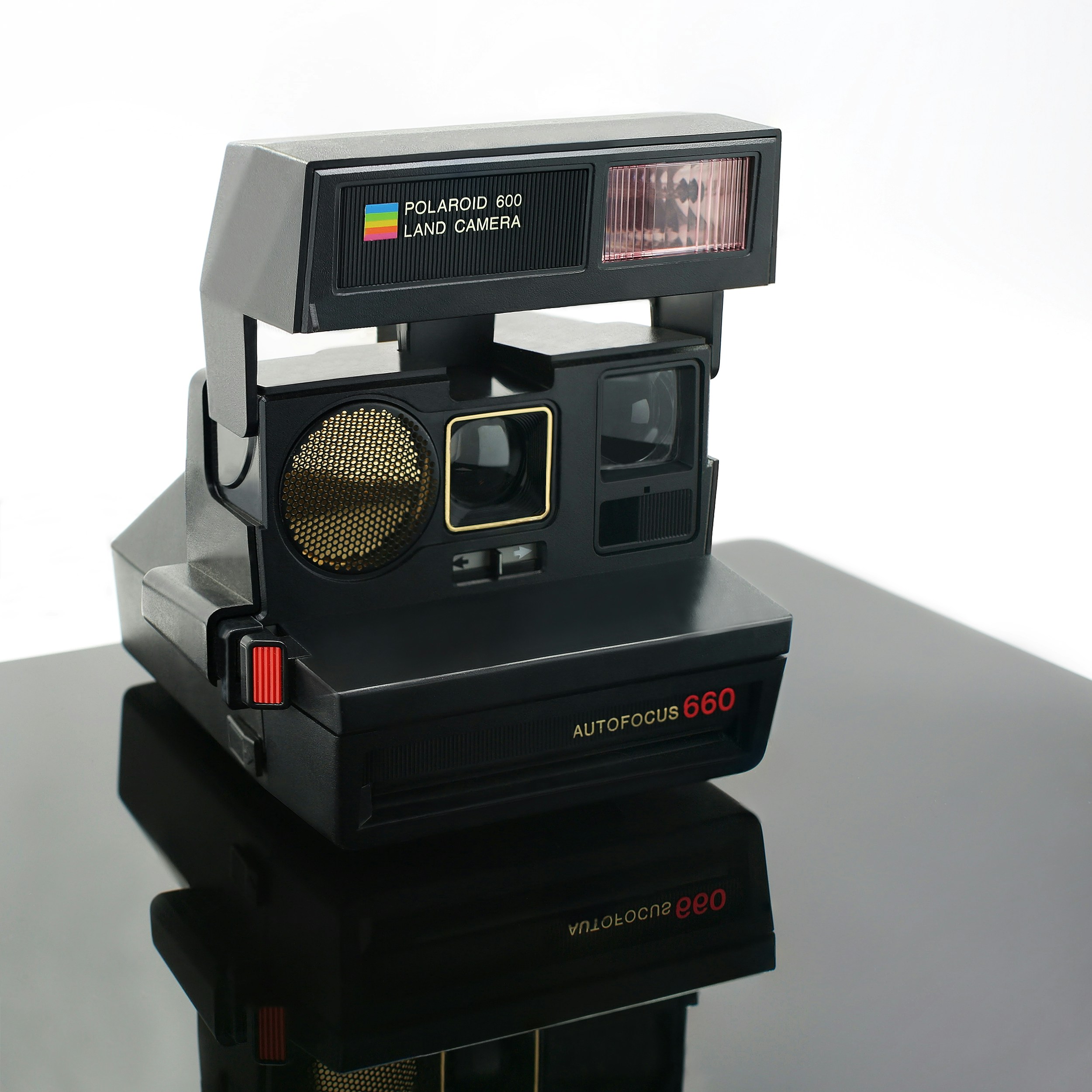 black-polaroid-instant-camera-on-white-surface