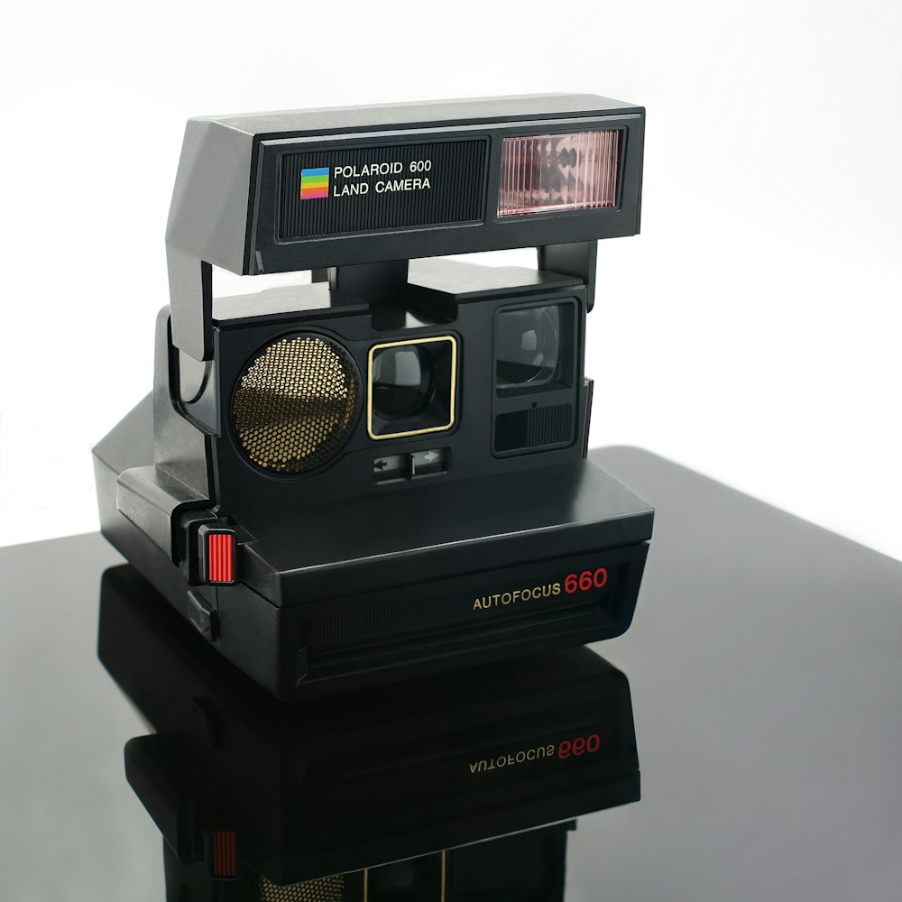 black polaroid instant camera on white surface