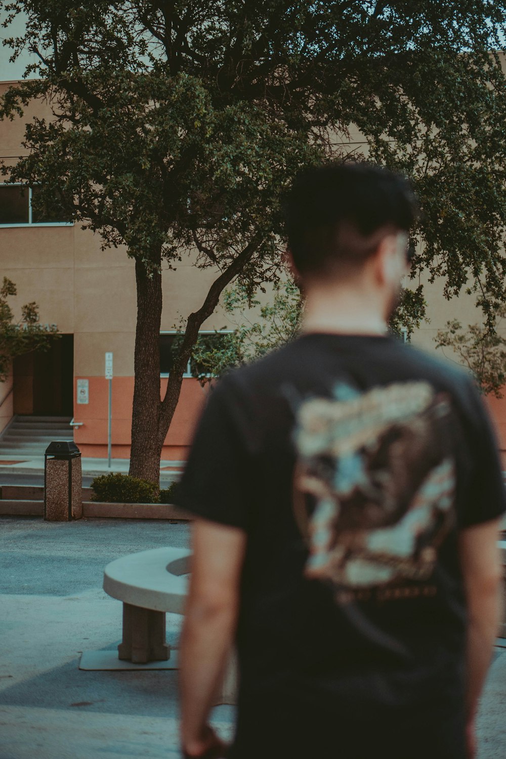 man in black and white crew neck t-shirt standing near swimming pool during daytime