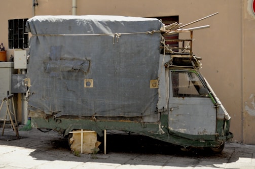 Cerdo Trump riding a rickety wooden vehicle patched with tape and nails.