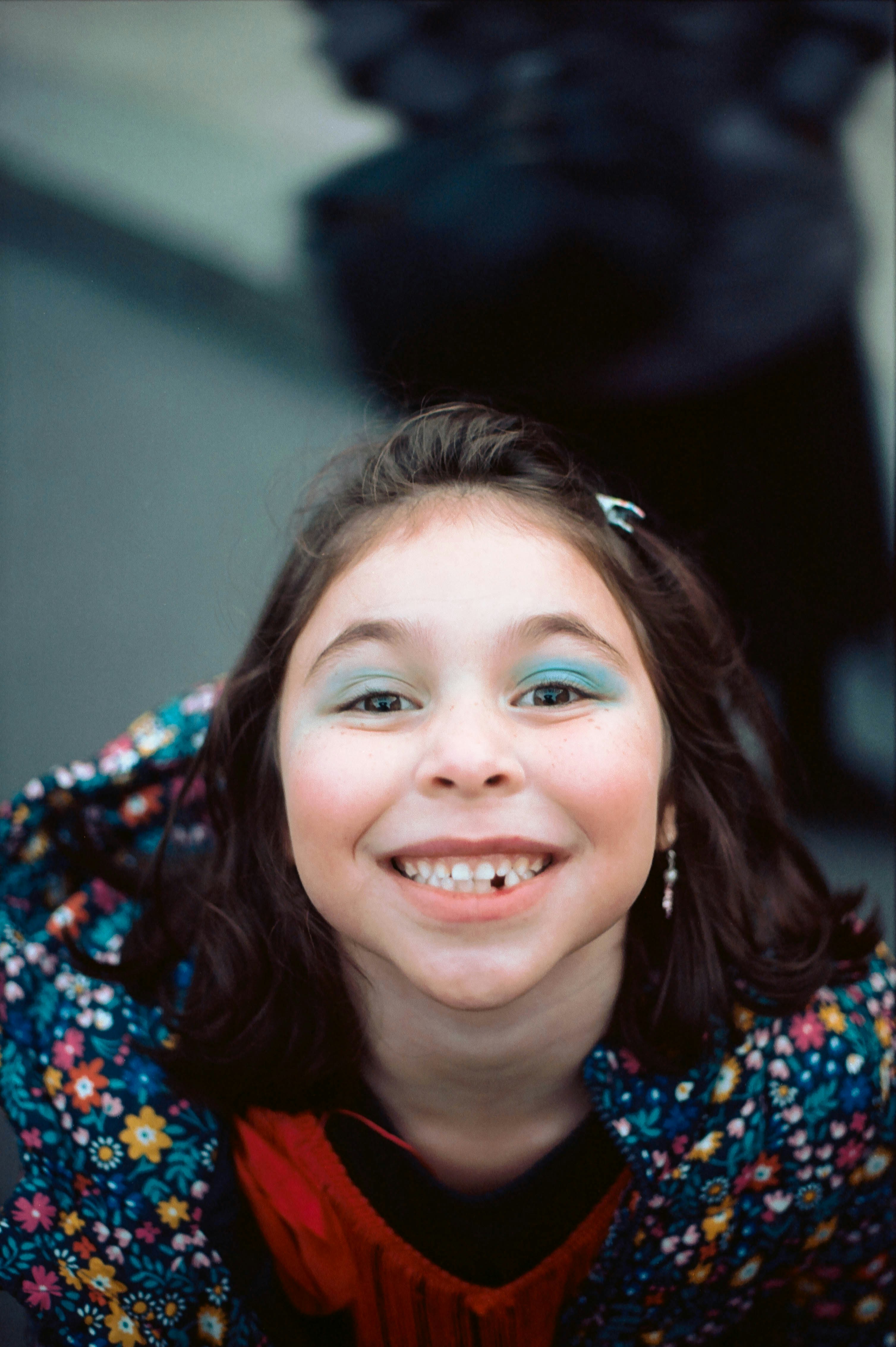 smiling girl in blue and red floral shirt