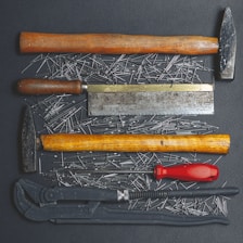 black and red handle hammer and black and silver hand tool