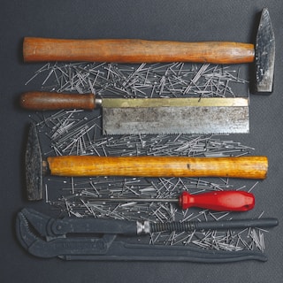 black and red handle hammer and black and silver hand tool