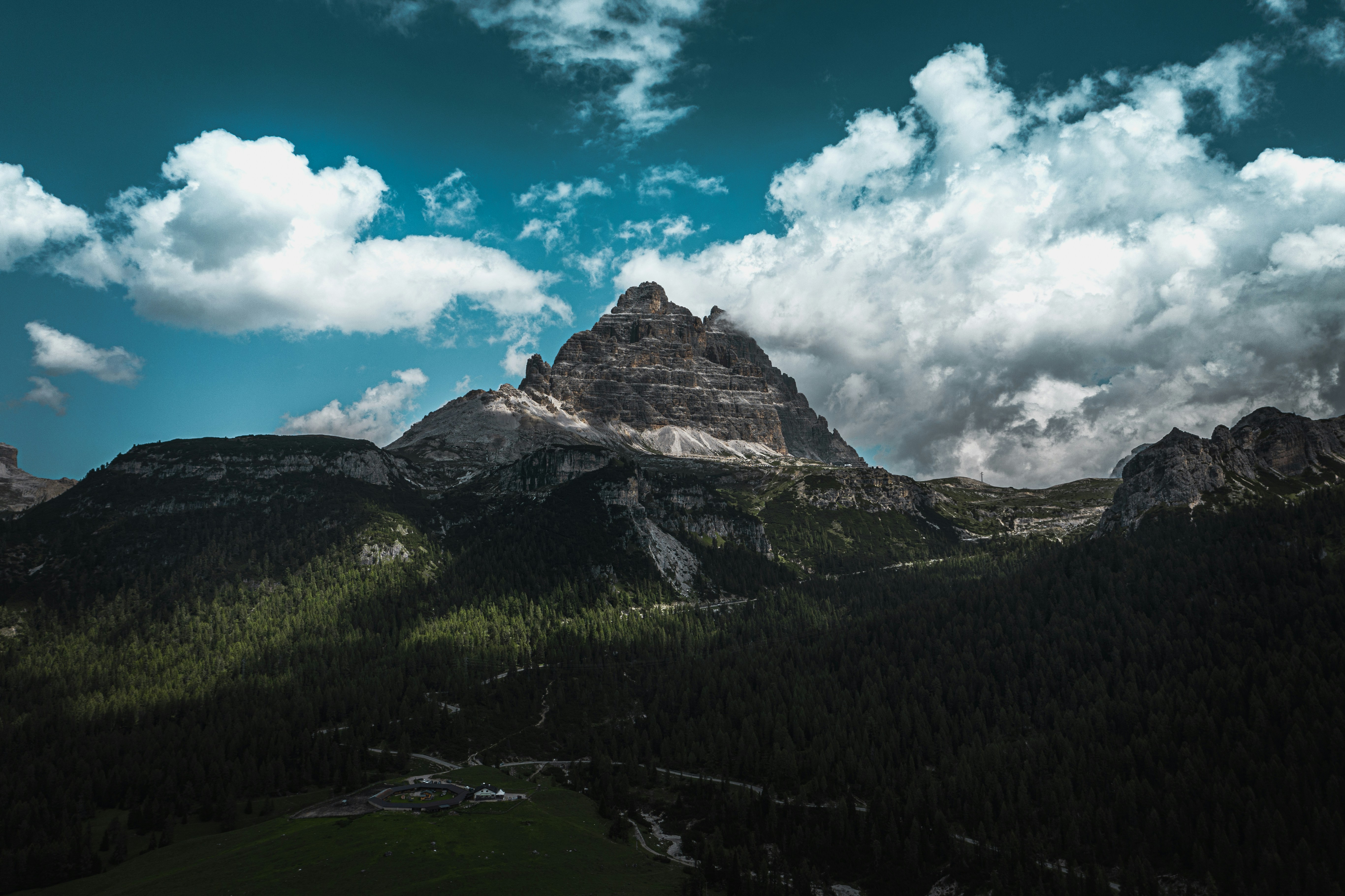 alberi verdi sulla montagna sotto il cielo blu e le nuvole bianche durante il giorno