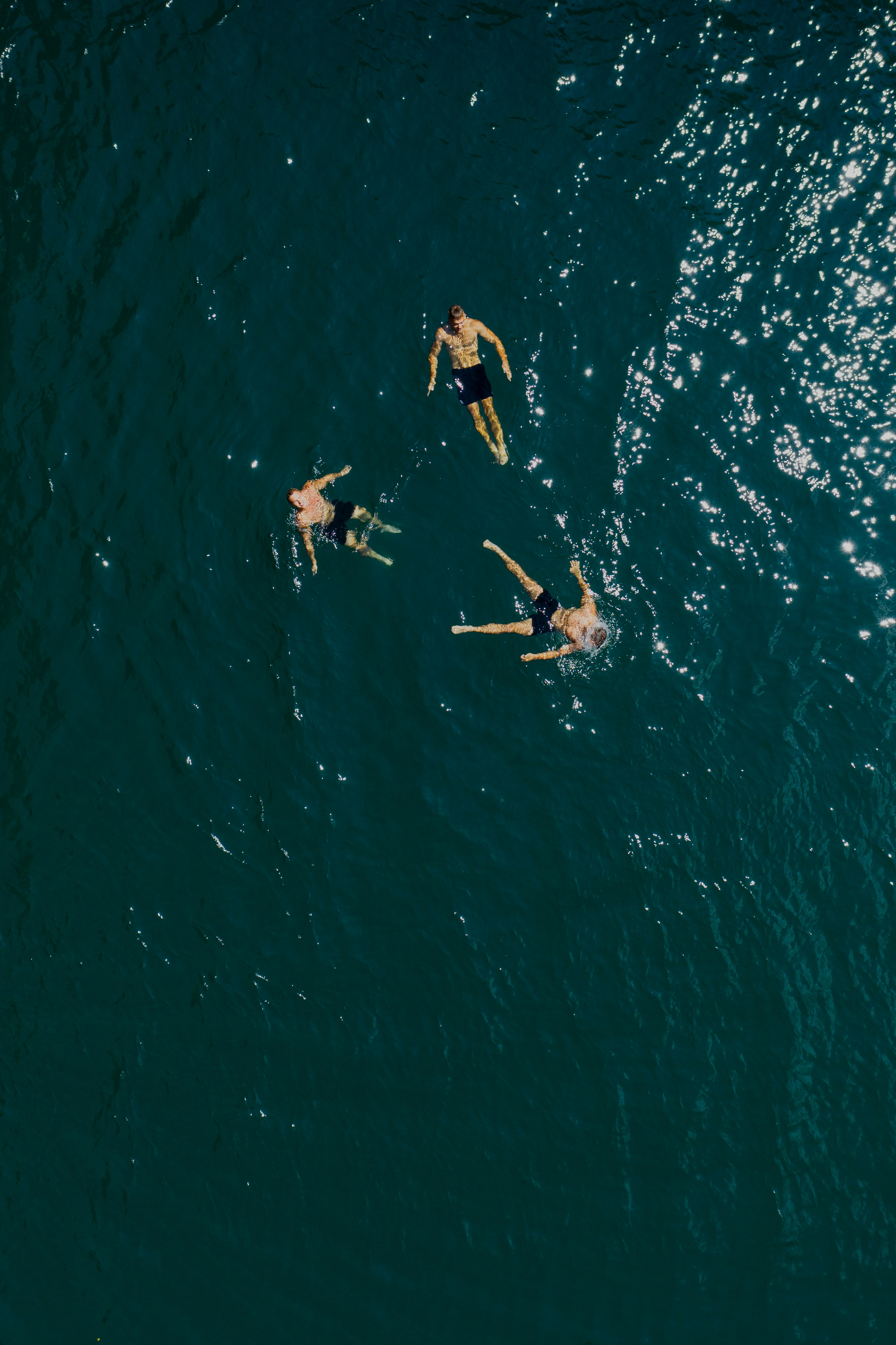 people surfing on blue sea during daytime