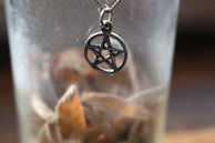 A detailed shot of the pentacle in the Queen’s hands, glowing softly with earthy tones.