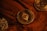 Three cryptocurrency coins on a wooden surface include Ethereum in the center, surrounded by Bitcoin coins. The coins are metallic with detailed engravings and symbols characteristic of blockchain technology.