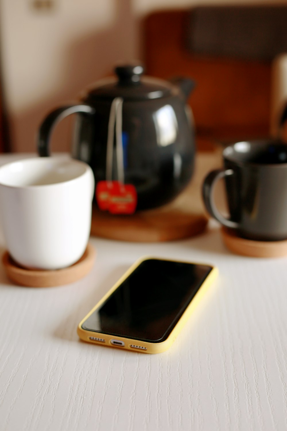 white samsung android smartphone beside black ceramic mug