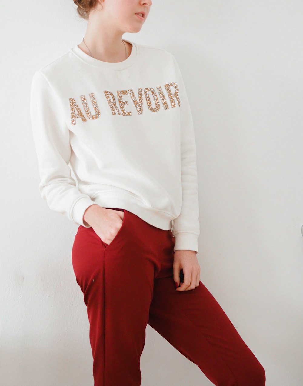 woman in white long sleeve shirt and red pants