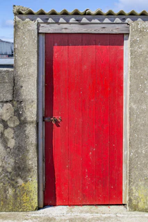 A sturdy industrial door painted vibrant red, standing firm on a commercial building