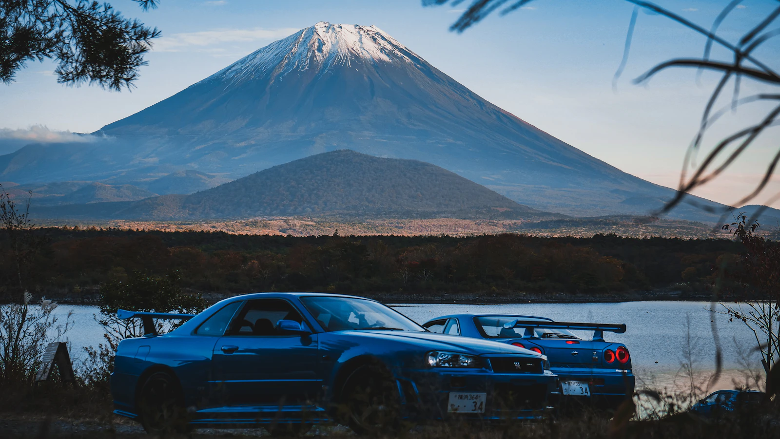Два Nissan Skyline GT-R у озера на фоне горы Фудзи