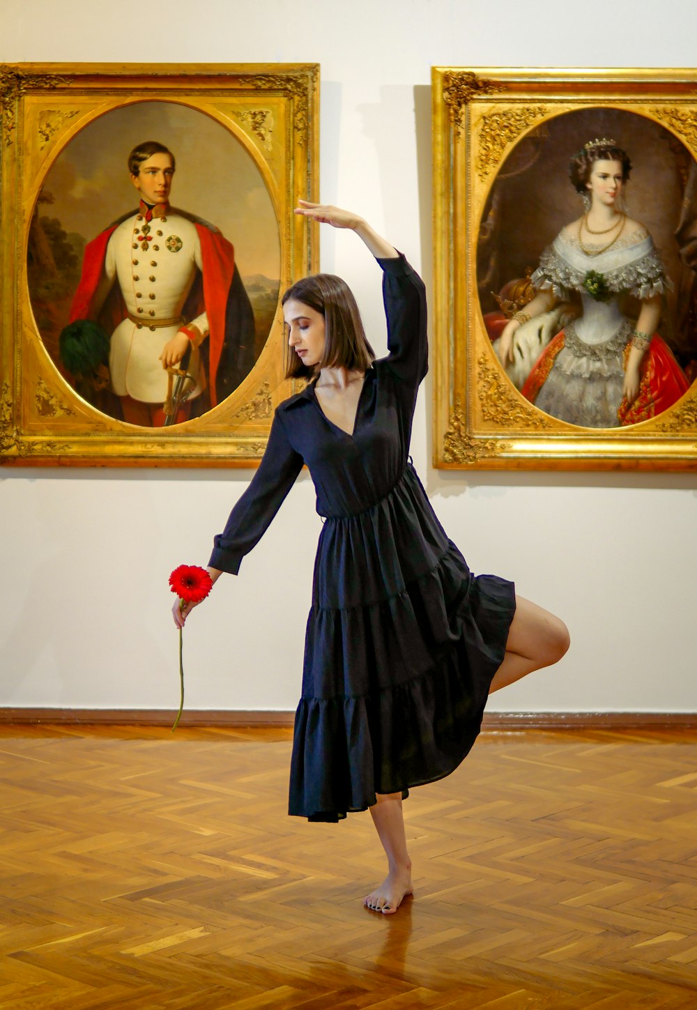 woman in black dress holding red heart balloon