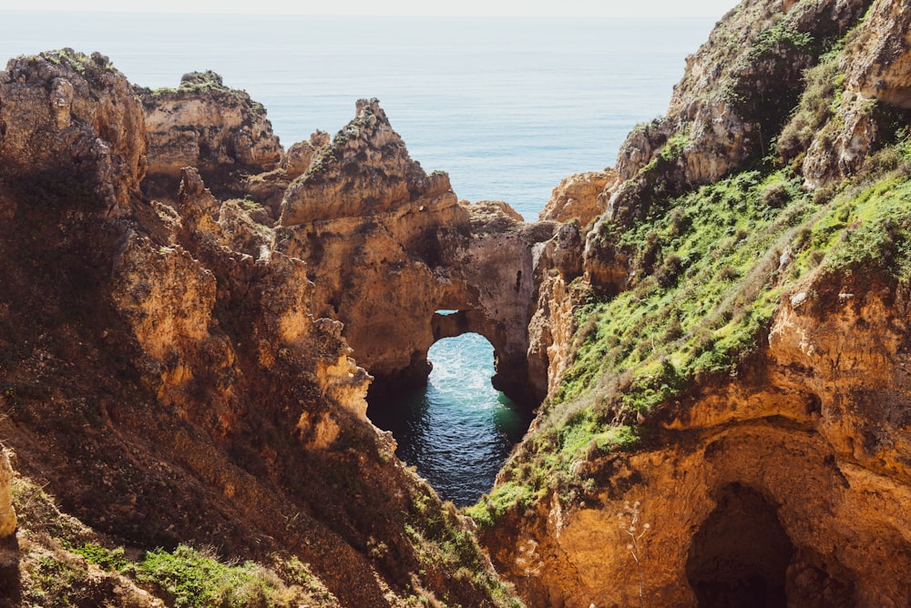 brown rock formation near body of water during daytime