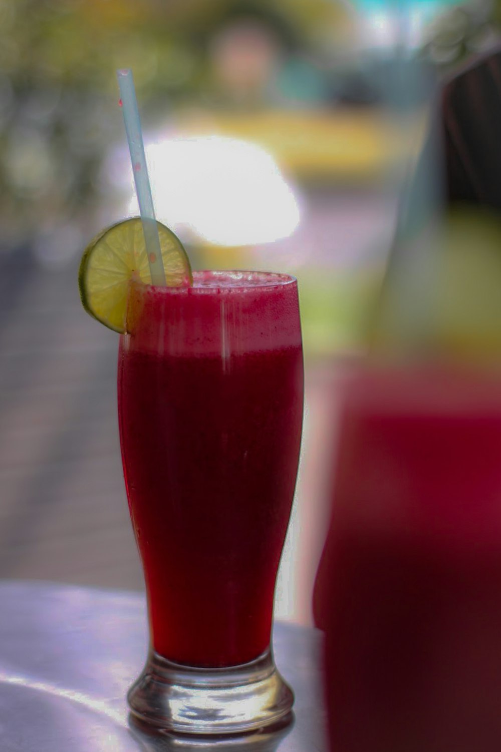 red liquid in clear drinking glass with sliced lemon