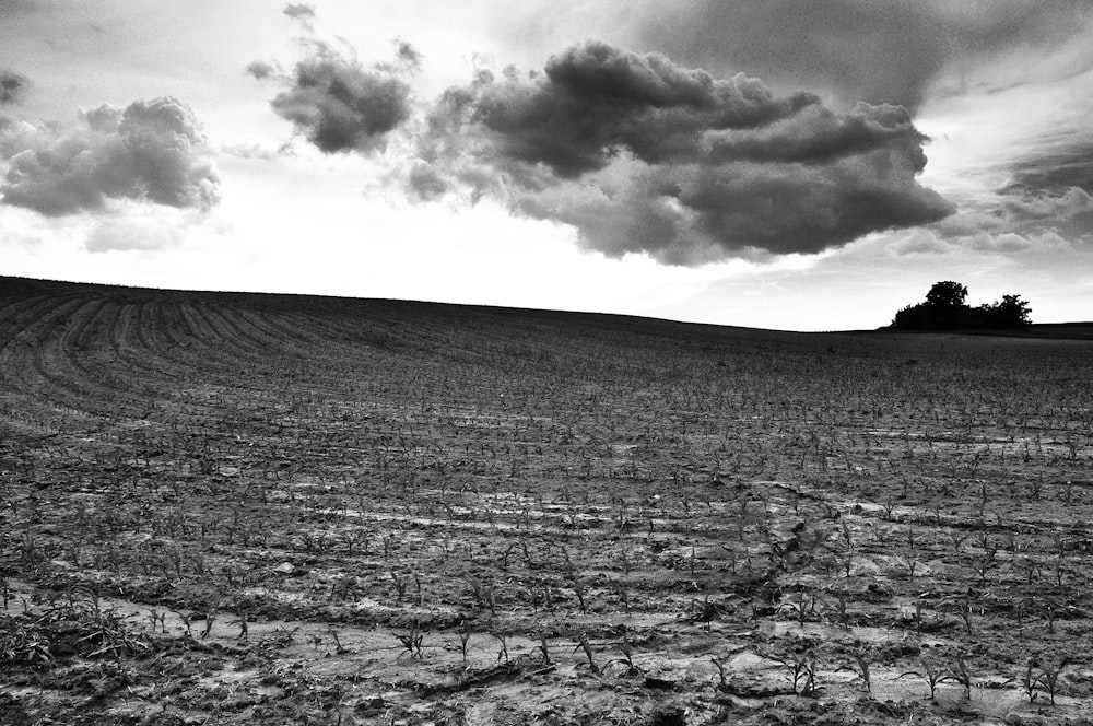 grayscale photo of mountain under cloudy sky