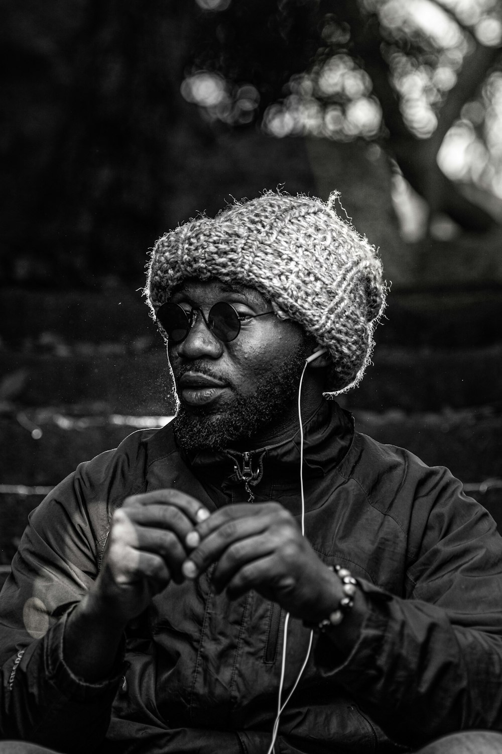 man in black jacket wearing white earbuds