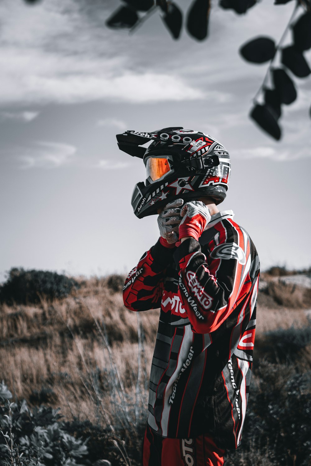 hombre en traje de motocicleta rojo y negro montando en motocicleta blanca y negra